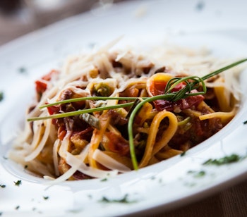 Autentisk italiensk fettuccine-pasta med frisk tomatsauce og basilikum serveret på en lokal restaurant i Firenze, der viser det toskanske køkkens enkelthed og kvalitet