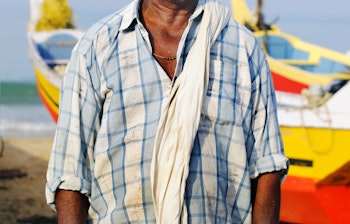 Ældre traditionel fisker med karakteristisk overskæg fra Kerala i Sydindien ved kysten, der repræsenterer den lokale fiskerkultur