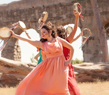 Unge kvinder i traditionelle græske dragter udfører rituel dans under kulturel fejring i Grækenland