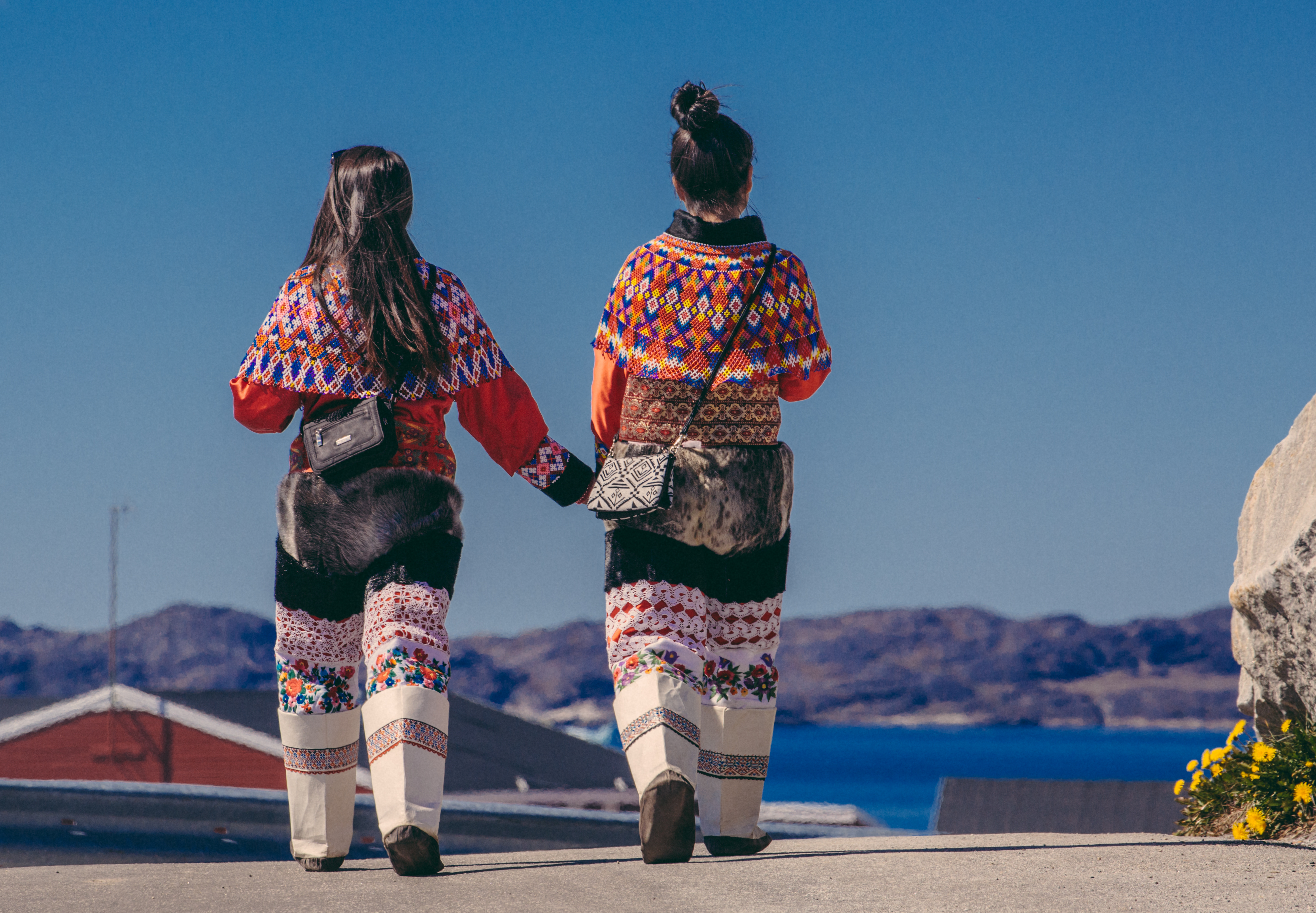 To kvinder i traditionelle grønlandske dragter ved Nuuk Fjord under kulturoplevelse i Grønland