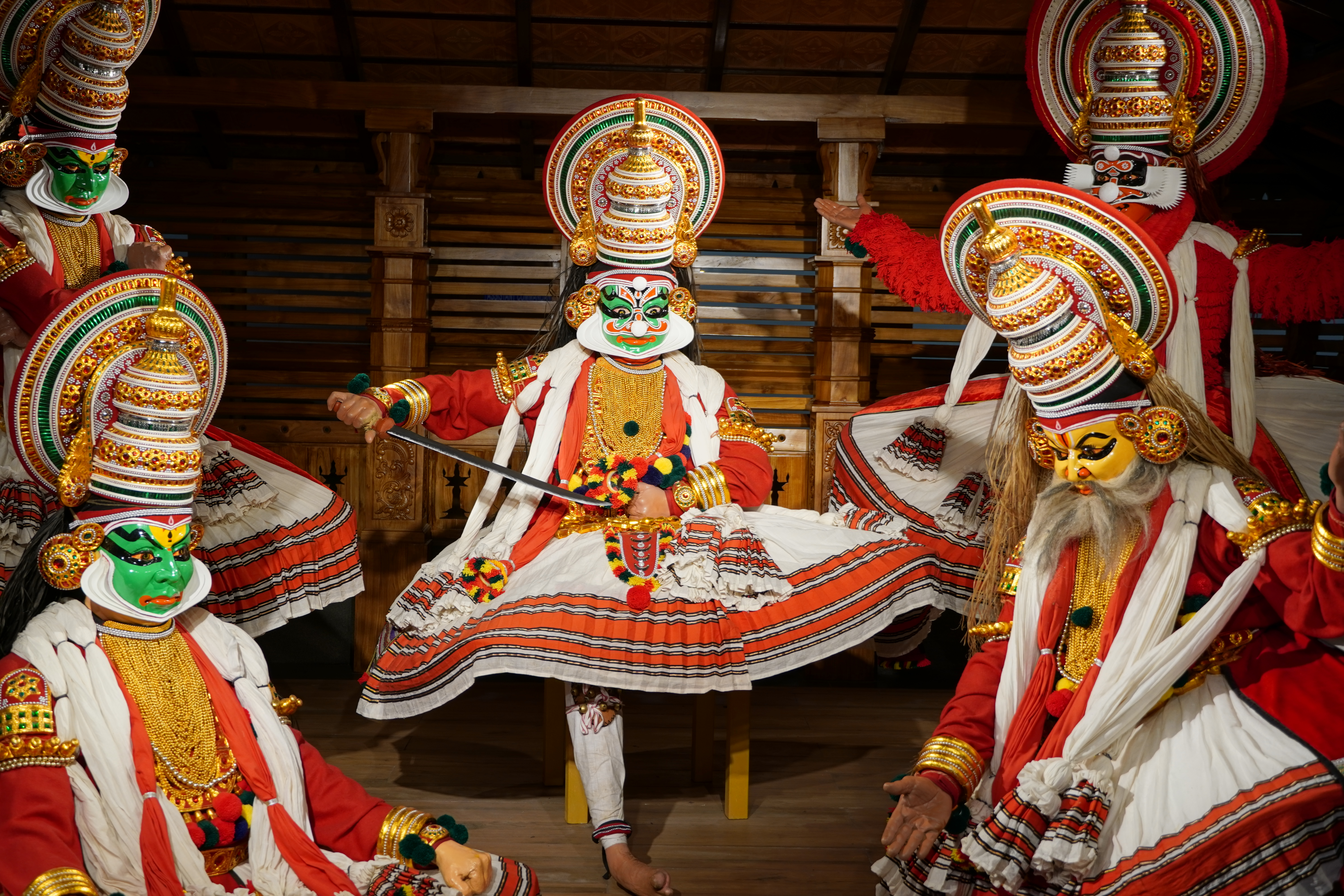 Farverige Kathakali dansere med traditionelle kostumer og makeup under en klassisk forestilling i Kerala, Indien