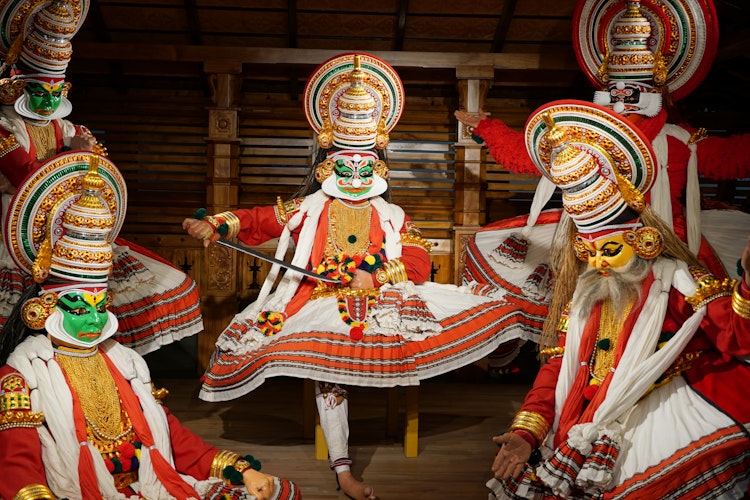 Farverige Kathakali dansere med traditionelle kostumer og makeup under en klassisk forestilling i Kerala, Indien