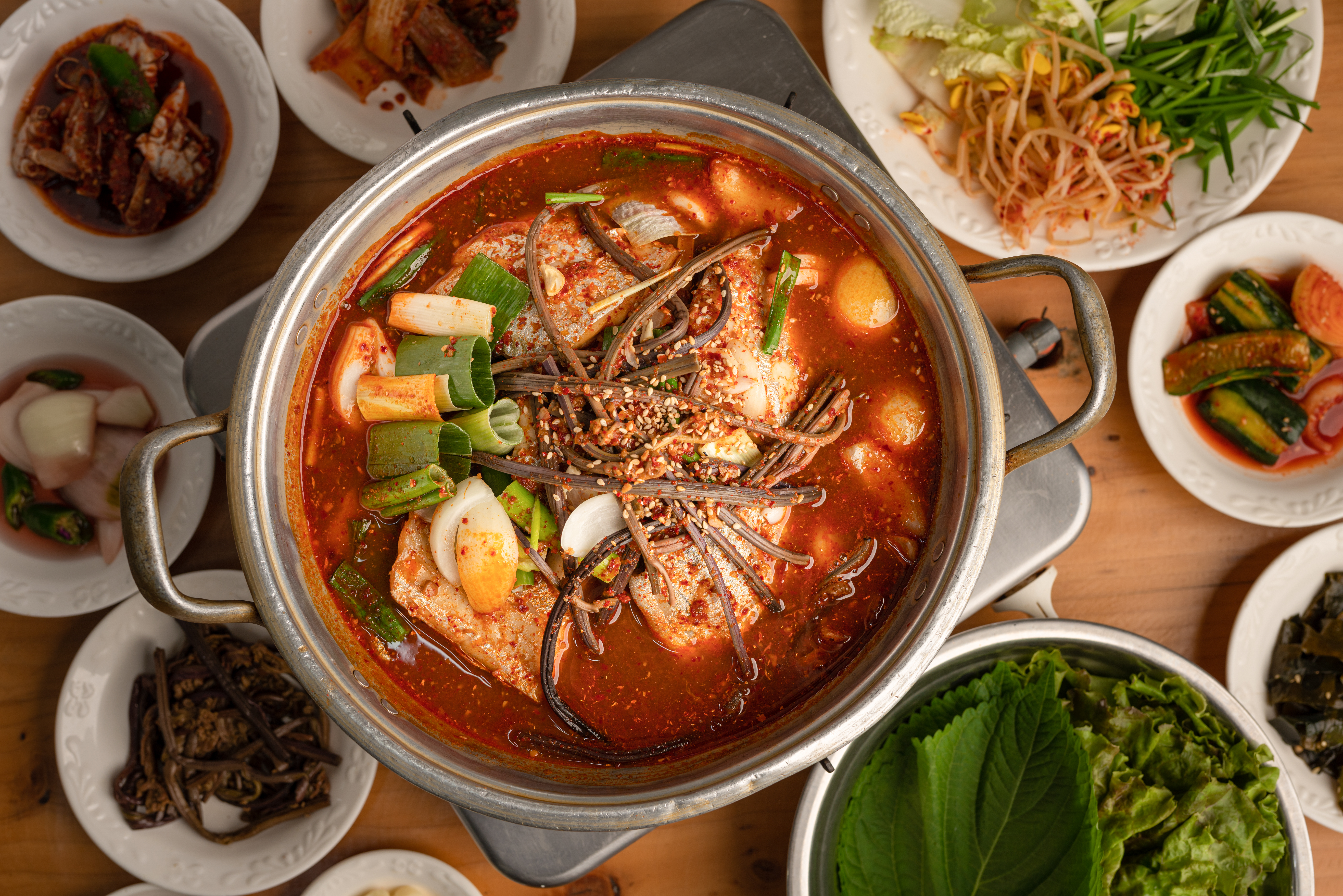 Traditionel koreansk ret med fisk kogt i sojasauce, serveret med farverige sideanretninger - en autentisk smagsoplevelse fra Seoul