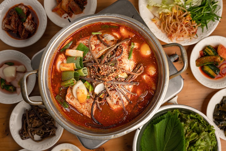 Traditionel koreansk ret med fisk kogt i sojasauce, serveret med farverige sideanretninger - en autentisk smagsoplevelse fra Seoul