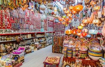 Farverig traditionel Mutrah Souk i Muscat, Oman, med træbelagte gange og lokale handlende der tilbyder autentiske omanske varer og håndværk