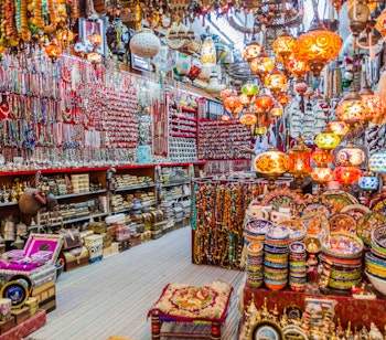 Farverig traditionel Mutrah Souk i Muscat, Oman, med træbelagte gange og lokale handlende der tilbyder autentiske omanske varer og håndværk