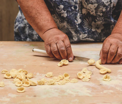 Lokal kvinde fremstiller traditionel orecchiette pasta i Baris gamle bydel - en kulinarisk specialitet fra Puglia-regionen i Syditalien