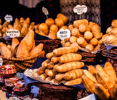 Traditionel polsk røget oscypek ost i kurve på udendørs marked i Krakow, Polen