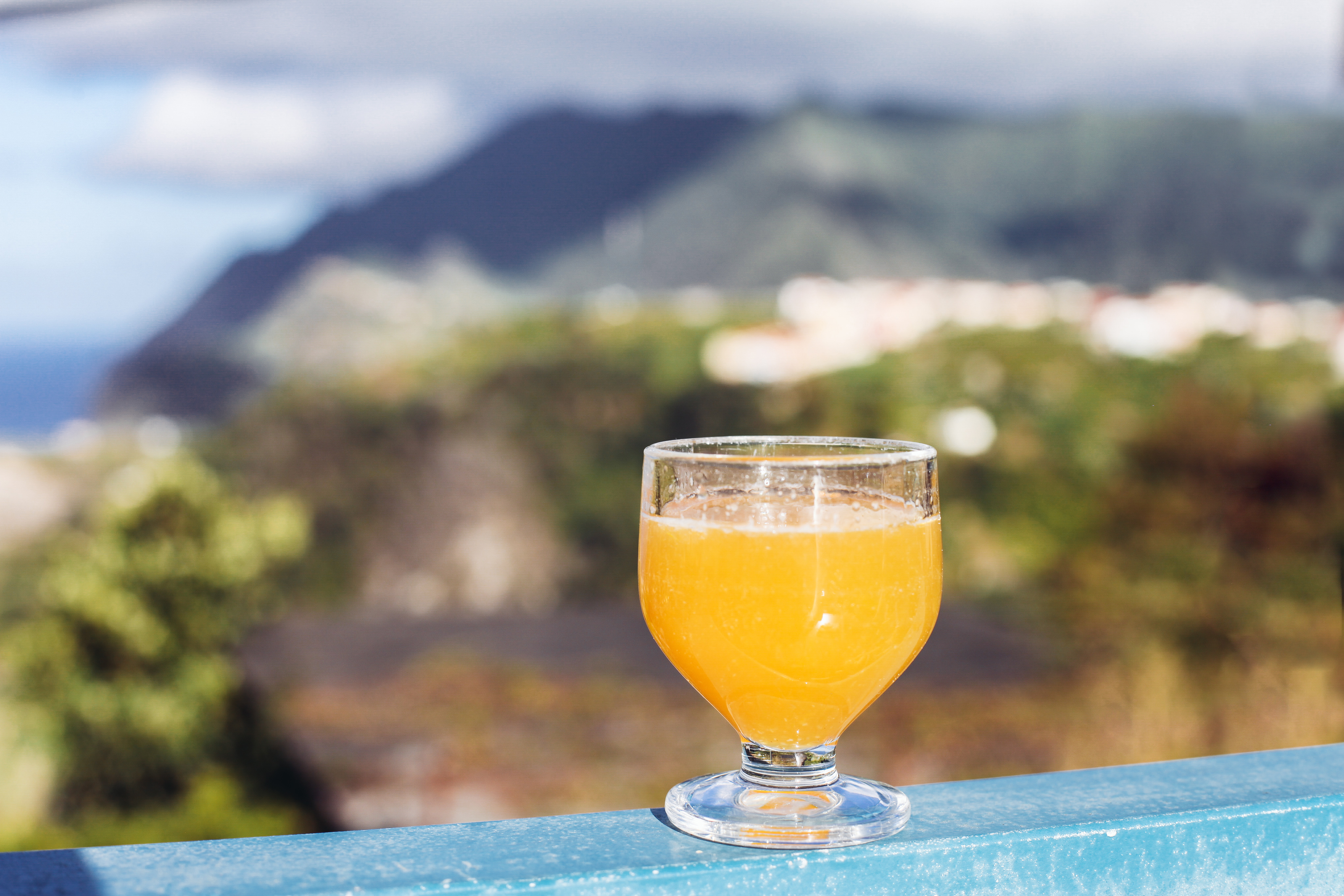 Traditionel madeiransk Poncha-drink serveret på cafeterasse med udsigt i Porto da Cruz, Madeira