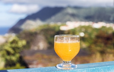 Traditionel madeiransk Poncha-drink serveret på cafeterasse med udsigt i Porto da Cruz, Madeira