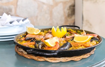 Autentisk spansk seafood paella serveret i strandrestaurant på Mallorca med muslinger og rejer