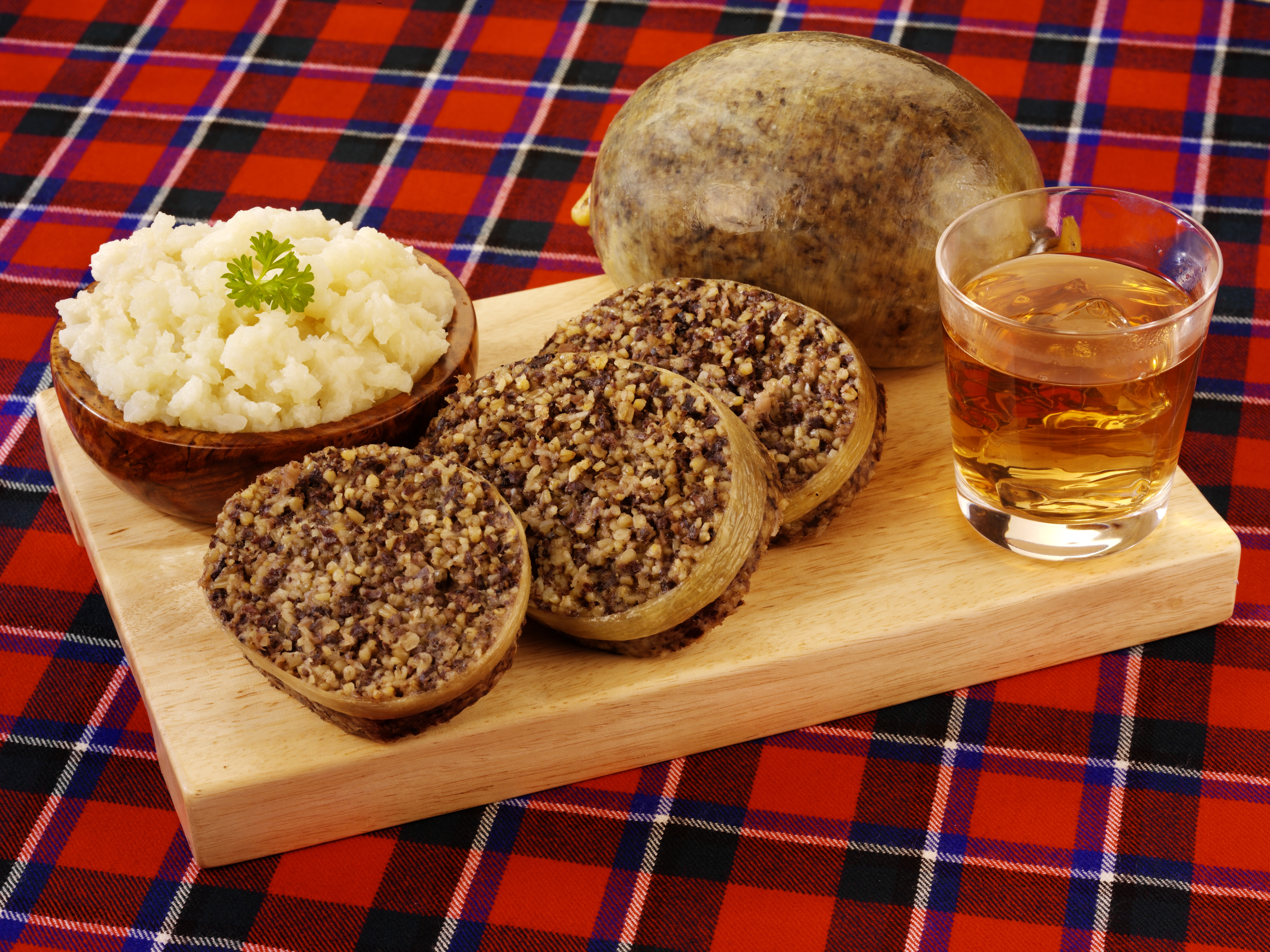 Traditionel skotsk haggis med neeps and tatties serveret på tartan dug til Burns Night fejring i Skotland