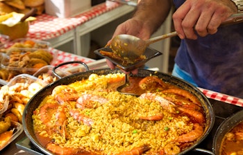 Traditionel spansk paella under tilberedning på et gademarked nær Barcelona Katedral med friske skaldyr og safran