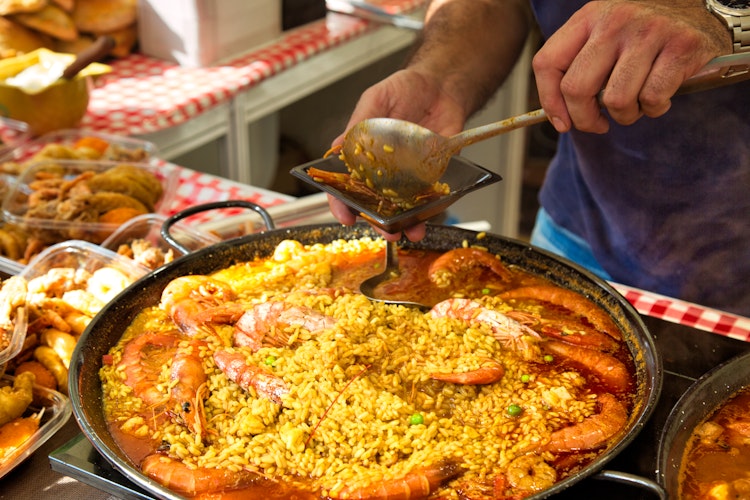 Traditionel spansk paella under tilberedning på et gademarked nær Barcelona Katedral med friske skaldyr og safran