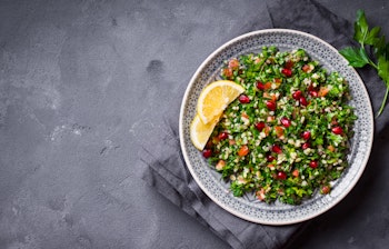 Traditionel tabbouleh salat med persille, mynte og bulgur - en populær mellemøstlig vegetarisk meze-ret serveret på rustik tallerken