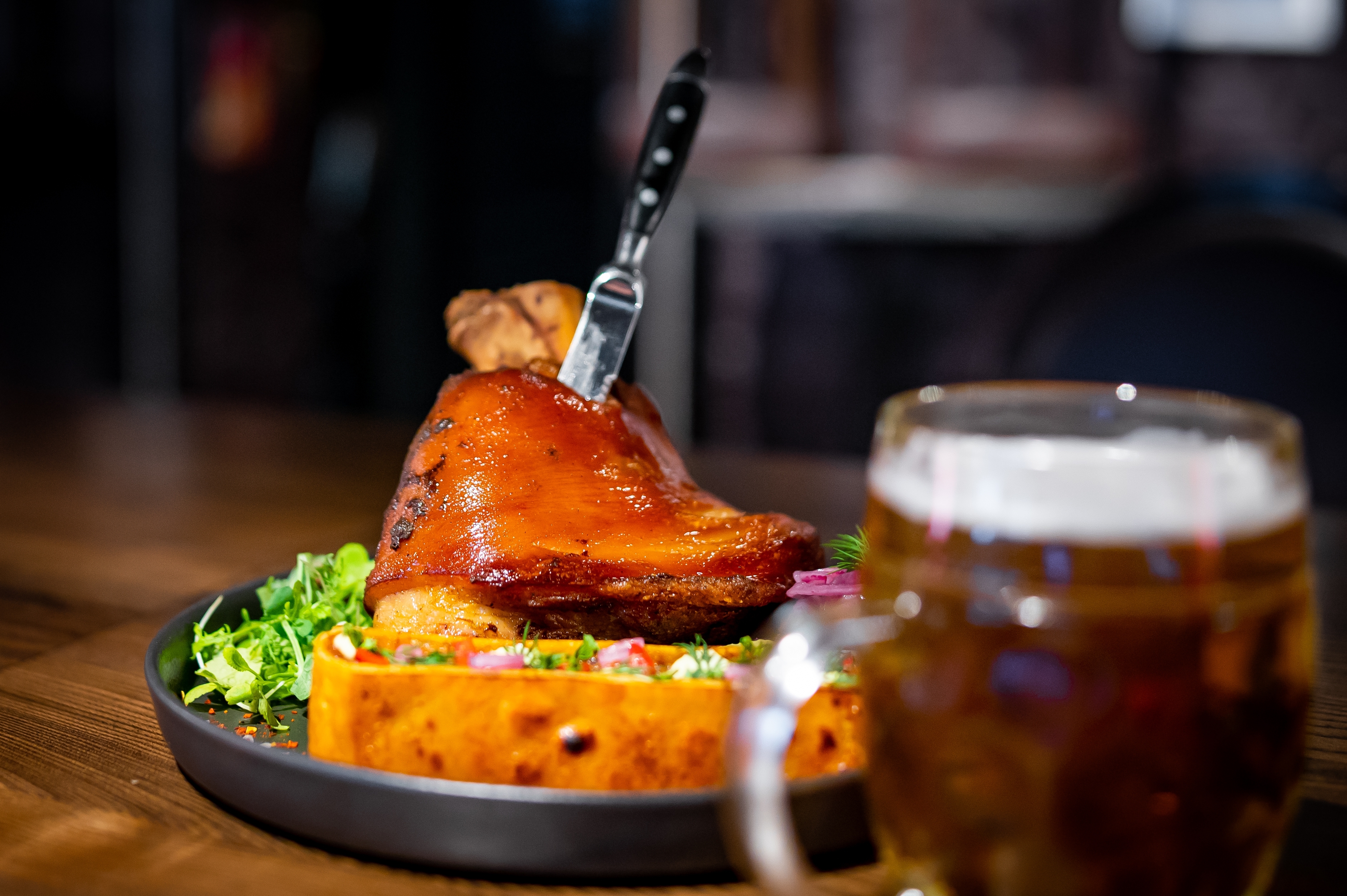 Traditionel tjekkisk flæskesteg med grøntsager og øl serveret på restaurant i Prag