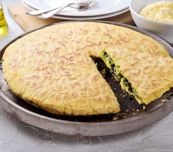 Traditionel Torta al testo fra Umbrien med fyld af cikorie og pecorino ost, serveret på en støbejernspande som en del af den autentiske umbriske madkultur