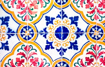 Farverige traditionelle azulejo-fliser på facaden af en historisk bygning i Lissabon, Portugal, der viser portugisisk kulturarv