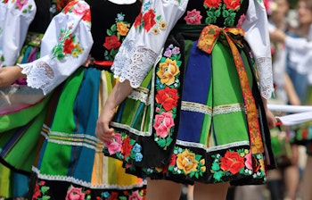 Traditionelle folkedansere i farverige broderede dragter under kulturel festival
