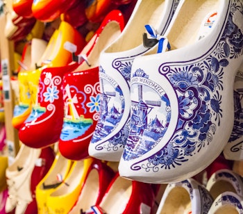 Farverige traditionelle hollandske træsko (klompen) med blå-hvide mønstre udstillet i en souvenirbutik i Holland