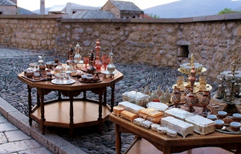 Farverige traditionelle kaffekopper udstillet ved den Gamle Bro i Mostar, Bosnien-Hercegovina - et smukt eksempel på lokalt kunsthåndværk