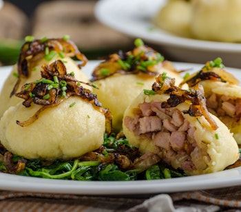 Traditionelle kartoffelknodler fyldt med kød og toppet med karamelliserede løg og friske urter