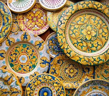 Farverige traditionelle keramiske tallerkener udstillet i Erice på Sicilien, der viser lokalt kunsthåndværk og kulturarv