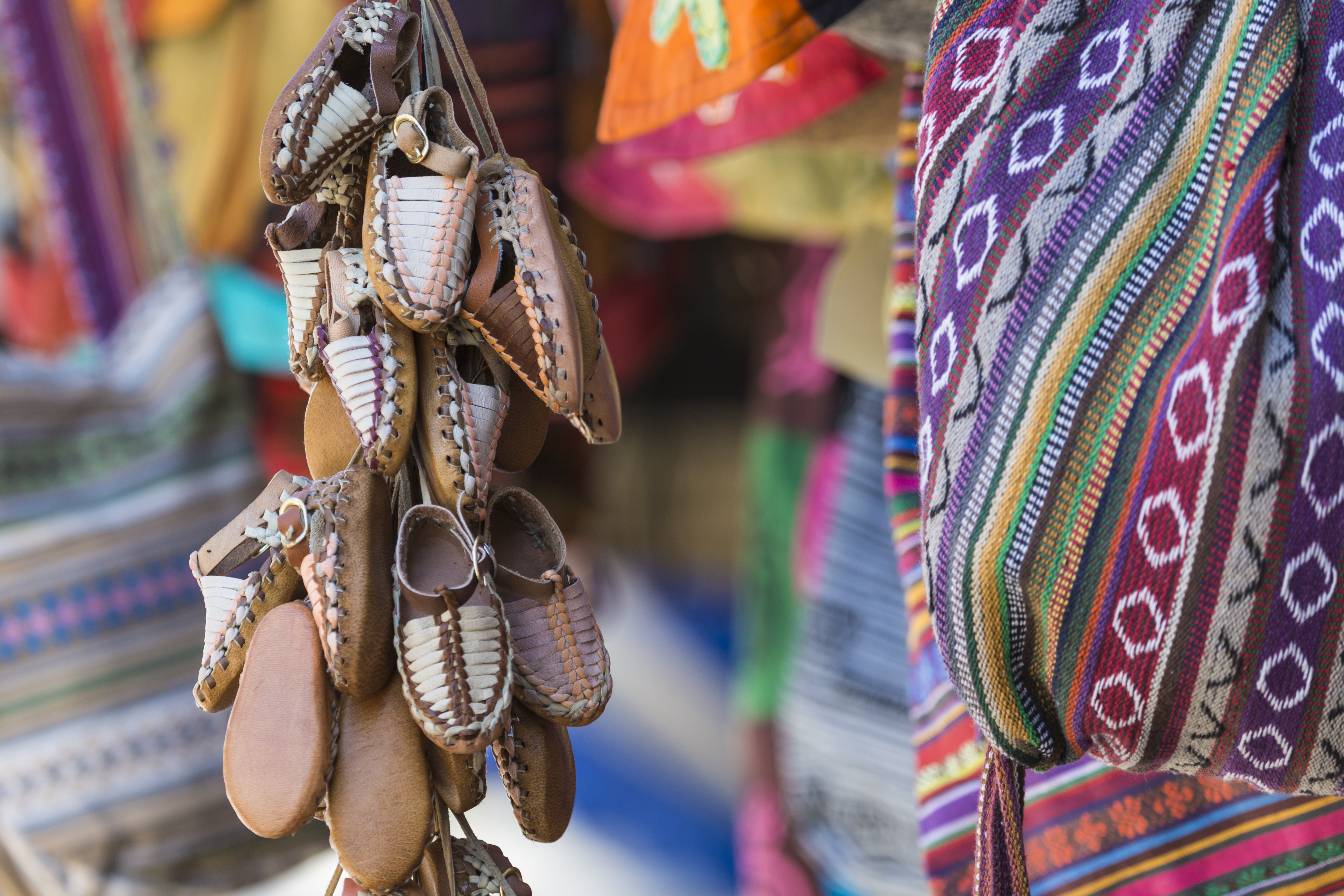 Traditionelle håndlavede læder sandaler og farverige tekstiler på balkan marked