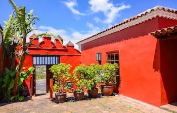 Traditionelle røde bygninger ved Casa del Vino La Baranda i El Sauzal på Tenerife med karakteristisk kanarisk arkitektur og frodige planter