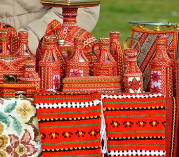 Farverige traditionelle souvenirs og håndværk på marked i Ohrid, Makedonien med dekorative miniaturehuse og håndvævede tæpper i balkanske mønstre