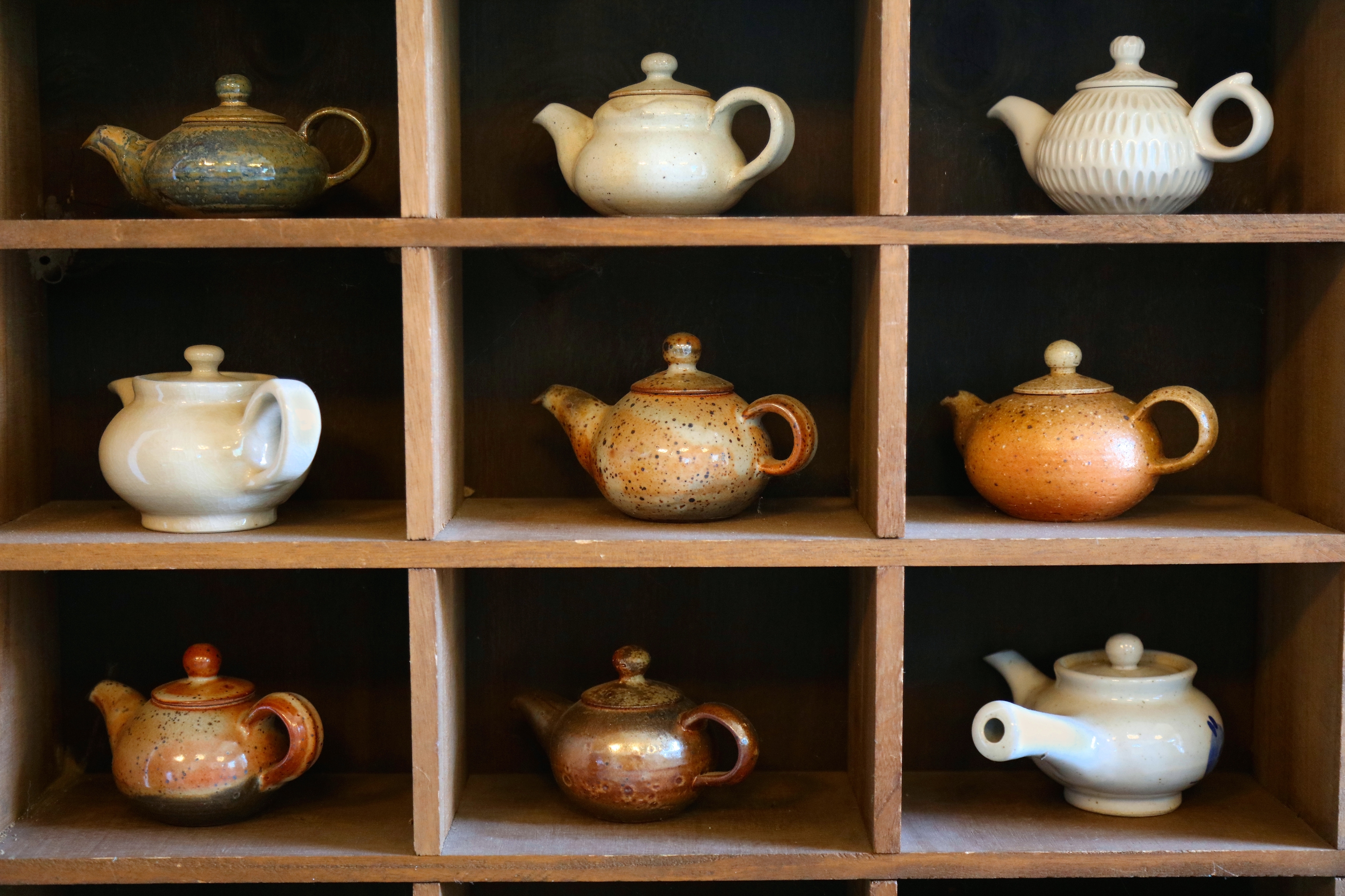 Samling af traditionelle koreanske tekander udstillet på træhylder i et tehus i Hwagae-myeon, Hadong, der viser mangfoldigheden i sydkoreansk tekultur