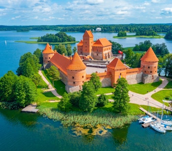 Luftfoto af det historiske Trakai slot på en ø i Galve-søen, Litauen, med karakteristiske røde tårne og blåt vand