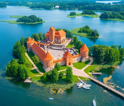 Luftfoto af det historiske Trakai-slot på en ø i Galve-søen i Litauen med røde murstensmure omgivet af blåt vand
