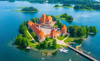 Luftfoto af det historiske Trakai-slot på en ø i Galve-søen i Litauen med røde murstensmure omgivet af blåt vand