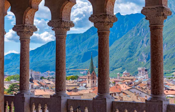 Udsigt over Trentos gamle bydel fra arkaderne i Castello del Buonconsiglio med kirketårne og Dolomitterne i baggrunden, Italien