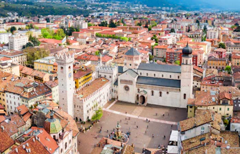 Luftfoto af Trento Katedral og det historiske bycentrum i Norditalien med karakteristiske terrakottatage og middelalderlig arkitektur