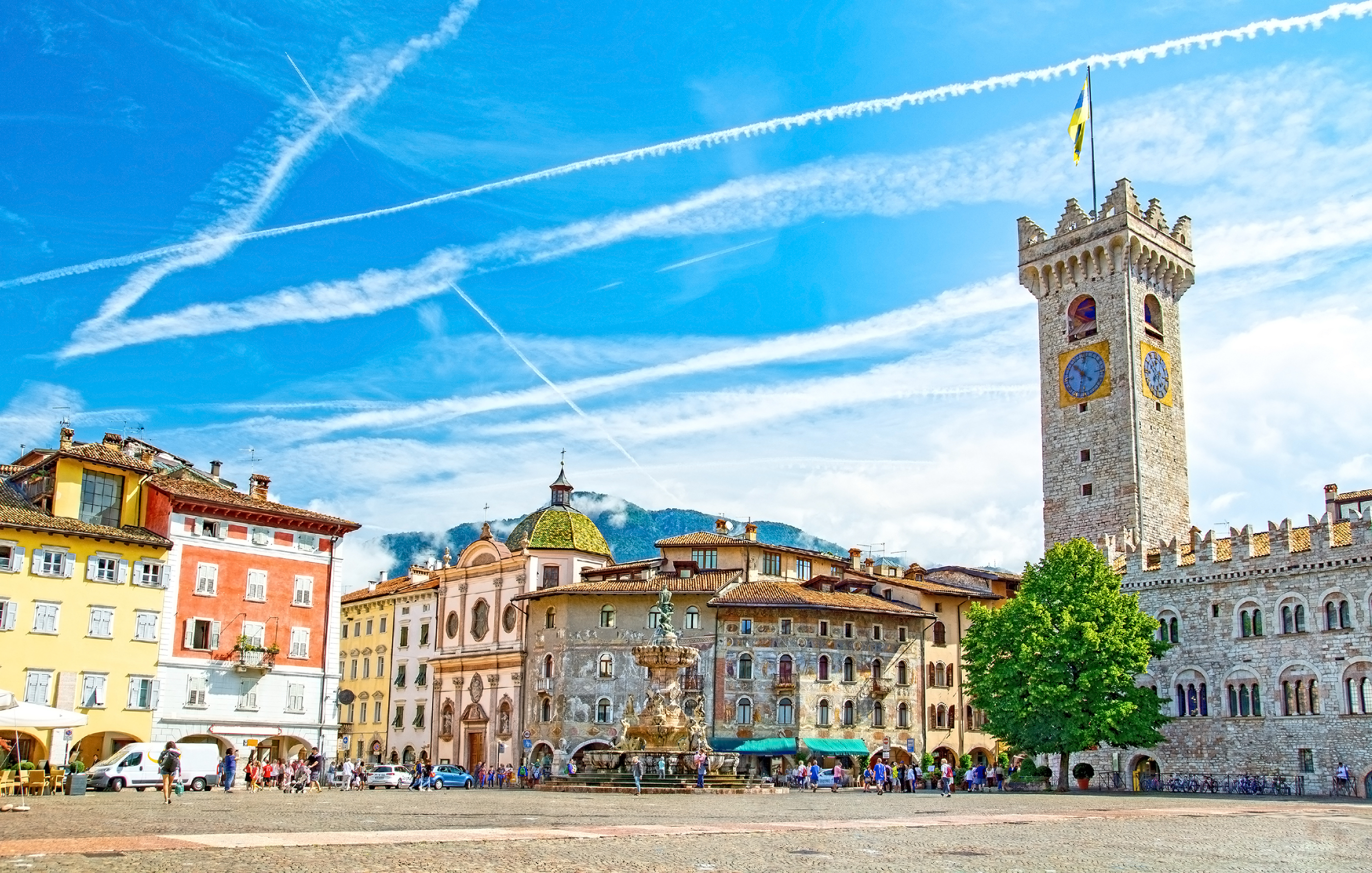 Den smukke Piazza Duomo i Trento, Italien, med Neptunfontænen, farverige renæssancebygninger og det historiske Torre Civica klokketårn