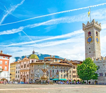 Den smukke Piazza Duomo i Trento, Italien, med Neptunfontænen, farverige renæssancebygninger og det historiske Torre Civica klokketårn