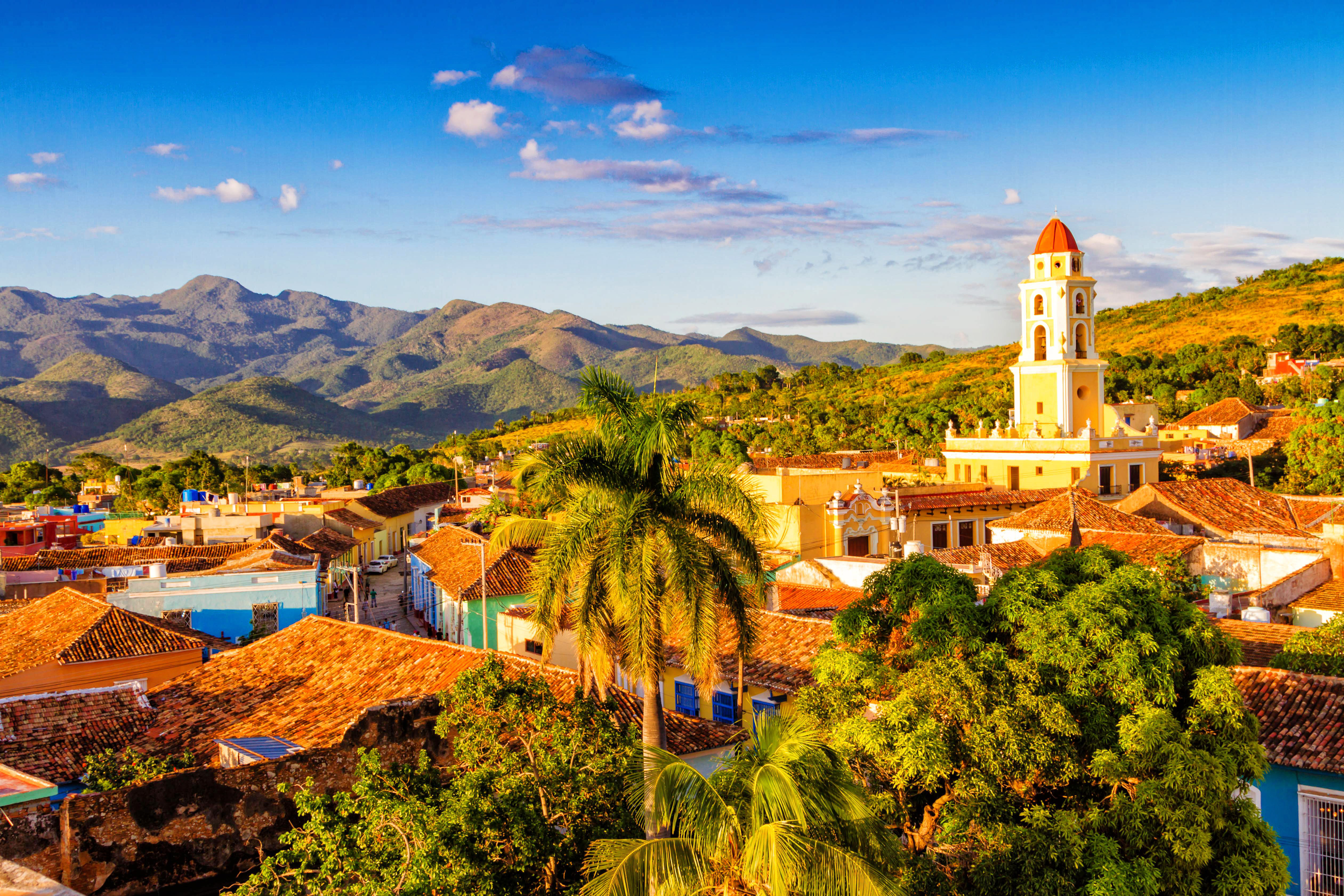 Panoramaudsigt over Trinidad Cuba med koloniale huse og kirketårn mod bjerglandskab
