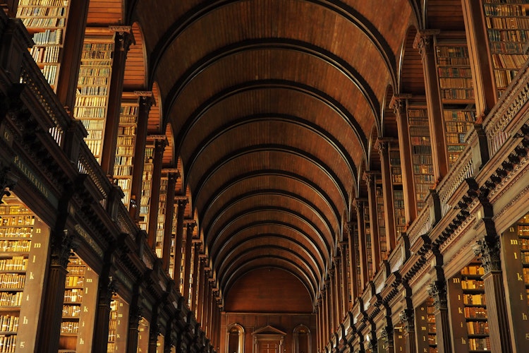 Det historiske Long Room i Trinity College biblioteket i Dublin, Irland, med hvælvede trælofter og imponerende bogreoler fyldt med gamle bøger