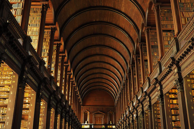 Det historiske Long Room i Trinity College biblioteket i Dublin, Irland, med hvælvede trælofter og imponerende bogreoler fyldt med gamle bøger