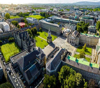 Luftfoto af Trinity College i Dublin med historiske bygninger, den ikoniske klokketårn og grønne områder - en højdepunkt på musikrejsen til Tradfest
