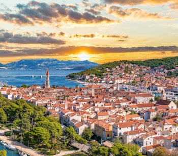 Luftfoto af UNESCO-beskyttede Trogir med middelalderlig arkitektur omgivet af det turkisblå Adriaterhav nær Split, Kroatien