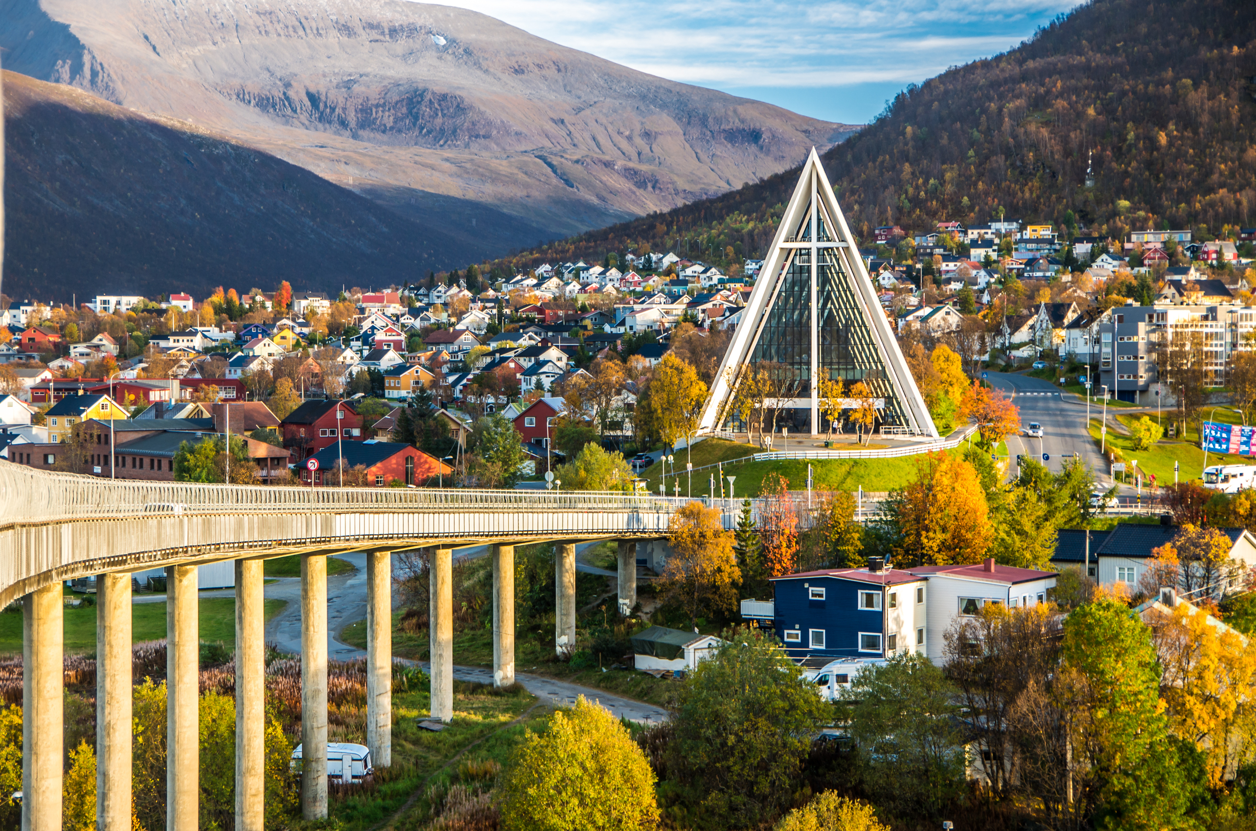 Tromso Arktisk Katedral og bybro i Norge om efteråret med farverige huse og bjerge