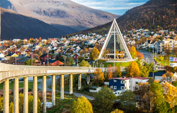 Tromso Arktisk Katedral og bybro i Norge om efteråret med farverige huse og bjerge