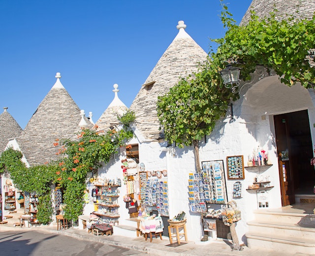Traditionelle trulli-huse med kegleformede stentage og souvenirbutikker i Alberobello, Italien