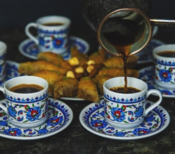 Traditionel tyrkisk baklava med pistacienødder serveret med sort kaffe, autentisk mellemøstlig dessertoplevelse på rejser til Tyrkiet