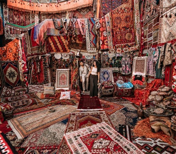 Farverig samling af traditionelle håndvævede tæpper i en tyrkisk basar i Istanbul, der viser landets rige kulturarv og kunsthåndværk