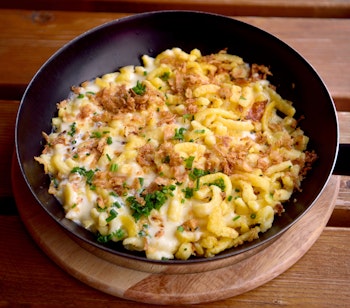 Traditionelle tyrolske spatzle-nudler med smeltet ost og karamelliserede løg, en autentisk østrigsk specialitet fra Tyrol-regionen