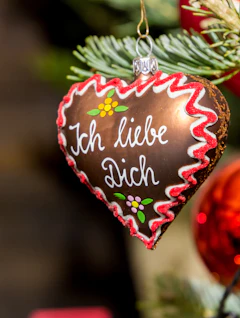 Traditionelt tysk julemarked hjerteornament med kærlighedsbesked hængende på juletræ
